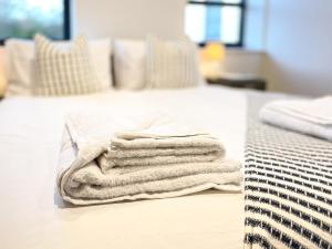 a pile of towels sitting on top of a bed at Luxury Ocean & North Foreland Golf View Escape in Broadstairs
