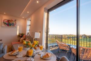 a room with a table with food and a large window at Luxury Ocean & North Foreland Golf View Escape in Broadstairs