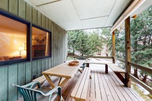 una terraza de madera con mesa y sillas. en Alpine Bliss en Brownsville