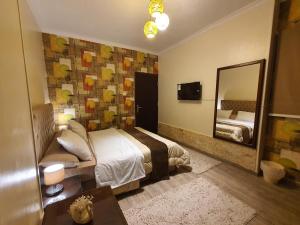 a bedroom with a bed and a large mirror at YOUVALA Serviced Apartment 2nd District in 6th Of October