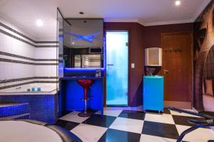 een blauwe keuken met een geruite vloer bij Motel Fantasy 2 (Adult Only) in Contagem