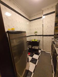 a kitchen with a refrigerator and a table in it at YOUVALA Serviced Apartment 2nd District in 6th Of October