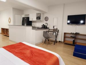 a room with a bed and a kitchen with a table at Runawasi Loft - Raywa 1 BDR, Centric and confortable. in Lima