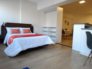 a bedroom with a large bed and a table at Runawasi Loft - Raywa 1 BDR, Centric and confortable. in Lima
