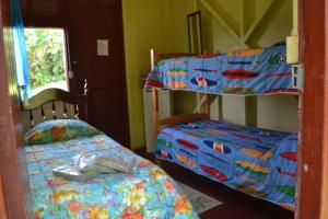 a bedroom with two bunk beds and a window at Pousada Avalon Paranapiacaba in Paranapiacaba