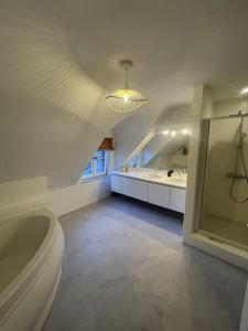 bagno con vasca, lavandino e specchio di Charmante villa a Wavre