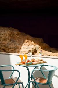 una mesa con una bandeja de comida y dos sillas en A Muralha en Tavira