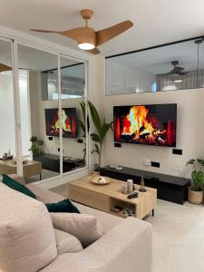 a living room with a couch and a fire in the wall at ZELUN Suite Torremolinos Center in Torremolinos