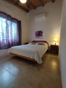 a bedroom with a white bed and two windows at Las Casuarinas in Piriápolis