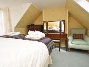 a bedroom with a bed and a desk and a mirror at 5 Bed in Castle Douglas KK169 in Castle Douglas