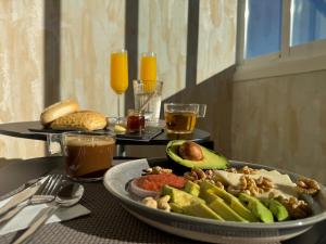 a table with a plate of food on a table with drinks at ZELUN Suite Torremolinos Center in Torremolinos