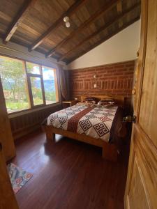 ein Schlafzimmer mit einem Bett in einem Zimmer in der Unterkunft Hostal Cloud Forest in Chugchilán