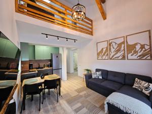 a living room with a couch and a table and a kitchen at Magic Mountain View Busteni in Buşteni