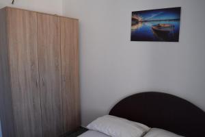 een slaapkamer met een bed en een houten kast bij Apartment Vidakovic in Budva