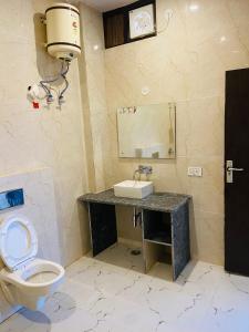 a bathroom with a toilet and a sink and a mirror at New Corbett Hotel and Resort in Belparāo