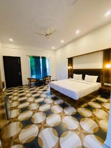 a bedroom with a large bed and a large tiled floor at New Corbett Hotel and Resort in Belparāo