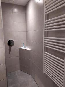 een badkamer met een douche en een tegelwand bij 107,5 Nieuw appartement met sauna in Westkapelle