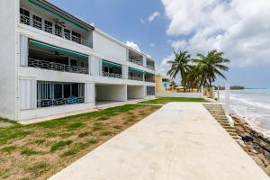 a building on the beach next to the ocean at Fortuna Paradise in Luquillo
