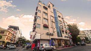 Vatika Inn Hotel City Center في أودايبور: مبنى طويل على شارع المدينة وبه سيارات