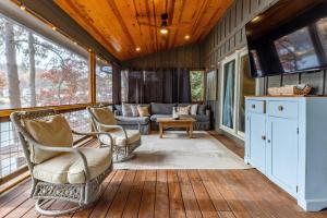 a screened in porch with chairs and a couch at Lakeside Hideaway in Waleska