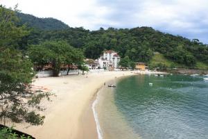 a beach with people swimming in the water at Corsário 205 in Angra dos Reis