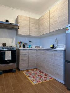 a kitchen with wooden cabinets and a rug on the floor at Tú Casa en Puerto Natales in Puerto Natales