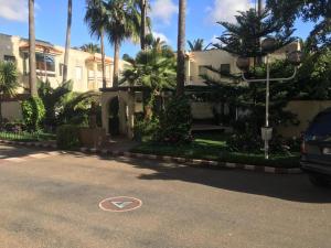 a house with palm trees in front of a street at DUPLEX VILLA RESIDENCE LA CORNICHE juste à coté de la plage in Mohammedia