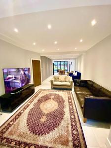 a living room with a couch and a flat screen tv at Luxury 5 bedroom house with Private car park in London in Hendon