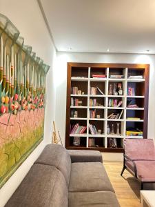 a living room with a couch and a book shelf at Center Apartment Easy in Tirana