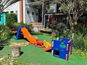 Pousada Casa da Noiva في جوارولوس: ساحة مع معدات لعب للأطفال على العشب