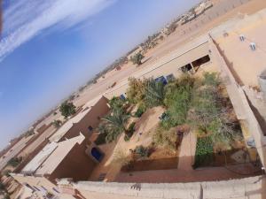 - une vue aérienne sur un bâtiment avec des palmiers dans l'établissement Auberge Camping La Liberté, à Merzouga