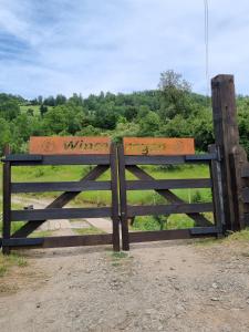 una valla de madera con escritura delante de un campo en Wincarayen Lodge & Cabañas en Panguipulli