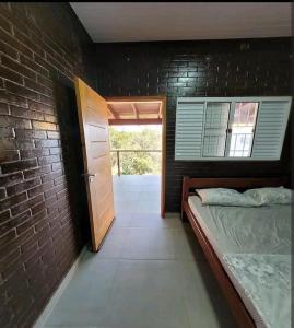 a bedroom with a bed and a brick wall at Casa Ecológica Ninho do Tucano in Bonito