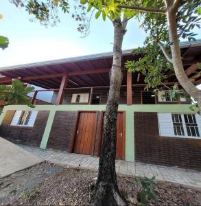 a brick house with a tree in front of it at Casa Ecológica Ninho do Tucano in Bonito