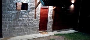 a brick building with a red door with a sign on it at Apartment Dulovine in Kola&scaron;in