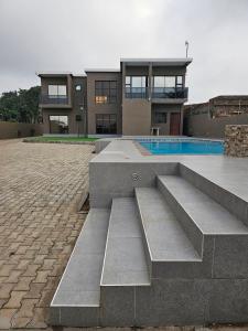 a building with a swimming pool in front of it at La Casa Modesta in Matola