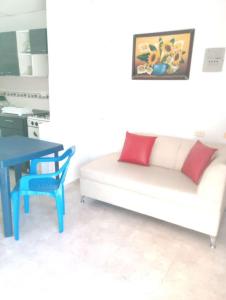 uma sala de estar com um sofá branco e uma mesa azul em Aparta Hotel Bethesda em Aguachica