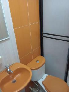 a bathroom with a toilet and a sink at Aparta Hotel Bethesda in Aguachica