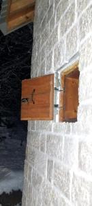 a brick wall with a wooden window on it at Apartment Dulovine in Kola&scaron;in