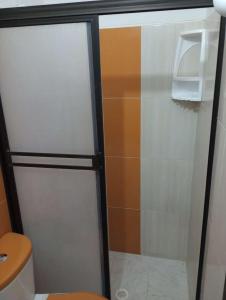 a glass door of a refrigerator in a bathroom at Aparta Hotel Bethesda in Aguachica