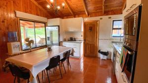a kitchen with a table and some chairs in it at Casa lican Ray vista al lago in Licán Ray
