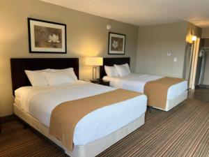 a hotel room with two beds and two lamps at Ramada by Wyndham London in London