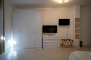 sala de estar con TV y armario blanco en Lamapulia, en Torre a Mare