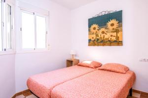 Un dormitorio con una cama y un cuadro en la pared. en Beach House Millares, en Carboneras