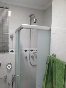 y baño con ducha y toalla verde. en Apto Home Office no Centro/Bela Vista de São Paulo, en São Paulo