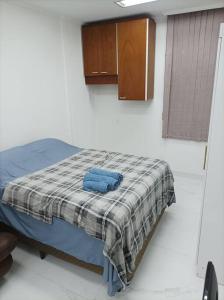 1 dormitorio con 1 cama con manta a cuadros en Apto Home Office no Centro/Bela Vista de São Paulo, en São Paulo