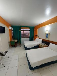 a hotel room with two beds and a table at Taj Mahal Hotel in Manaus