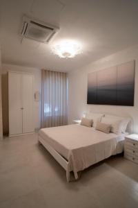 1 dormitorio blanco con 1 cama grande y techo en Lamapulia, en Torre a Mare