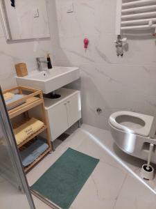 Un baño blanco con lavabo e inodoro. en Moon Apartman Zlatibor, en Zlatibor 27 fotos más