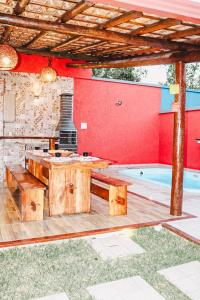 a patio with a wooden table and a pool at Residencial Ilha do Sol in Arraial d'Ajuda